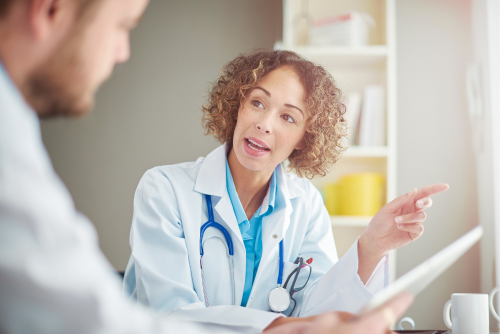 Das Bild zeigt eine Ärztin und einen Patienten im Gespräch